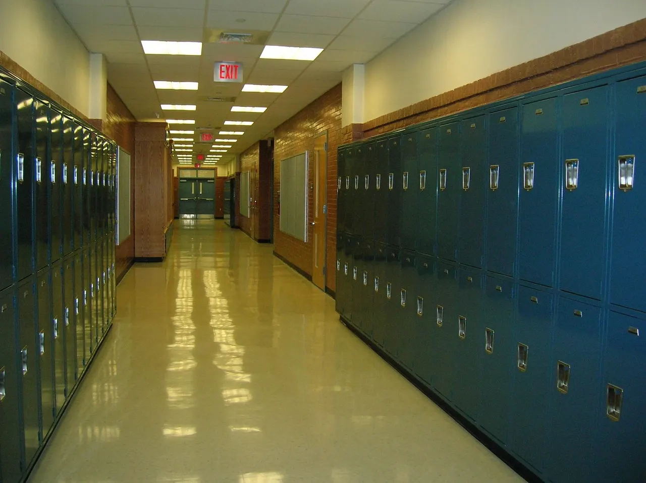 A school corridor lined with lockers, daylight falling down the hall