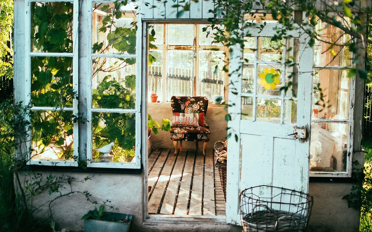 A weathered door standing open onto a rustic room, daylight coming through