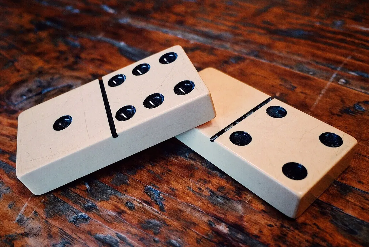 Wooden dominoes resting on a dark wooden table