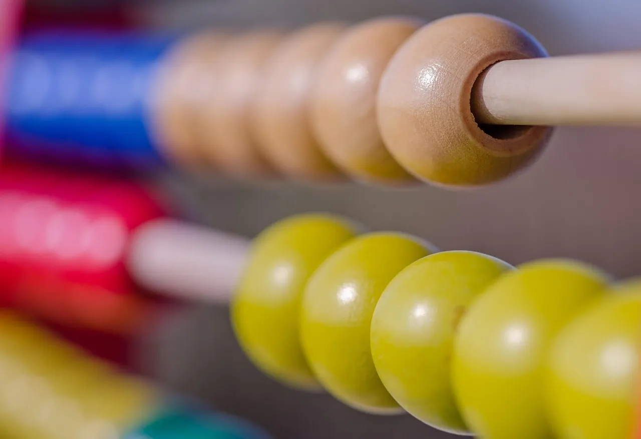Close-up of wooden abacus beads slid together into groups along their rods