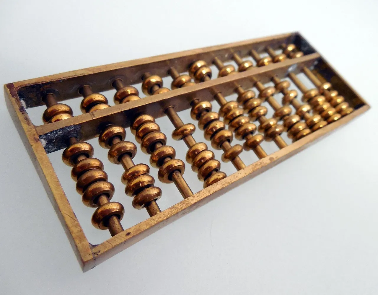 A wooden soroban abacus resting on a pale surface
