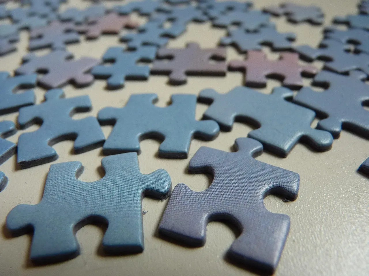 A part-built jigsaw in muted blues with a single piece-shaped gap in the middle