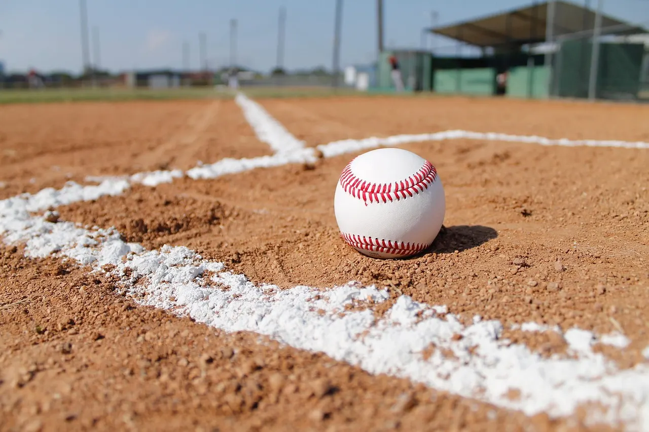 Fresh white chalk lines on the red dirt of an empty baseball diamond